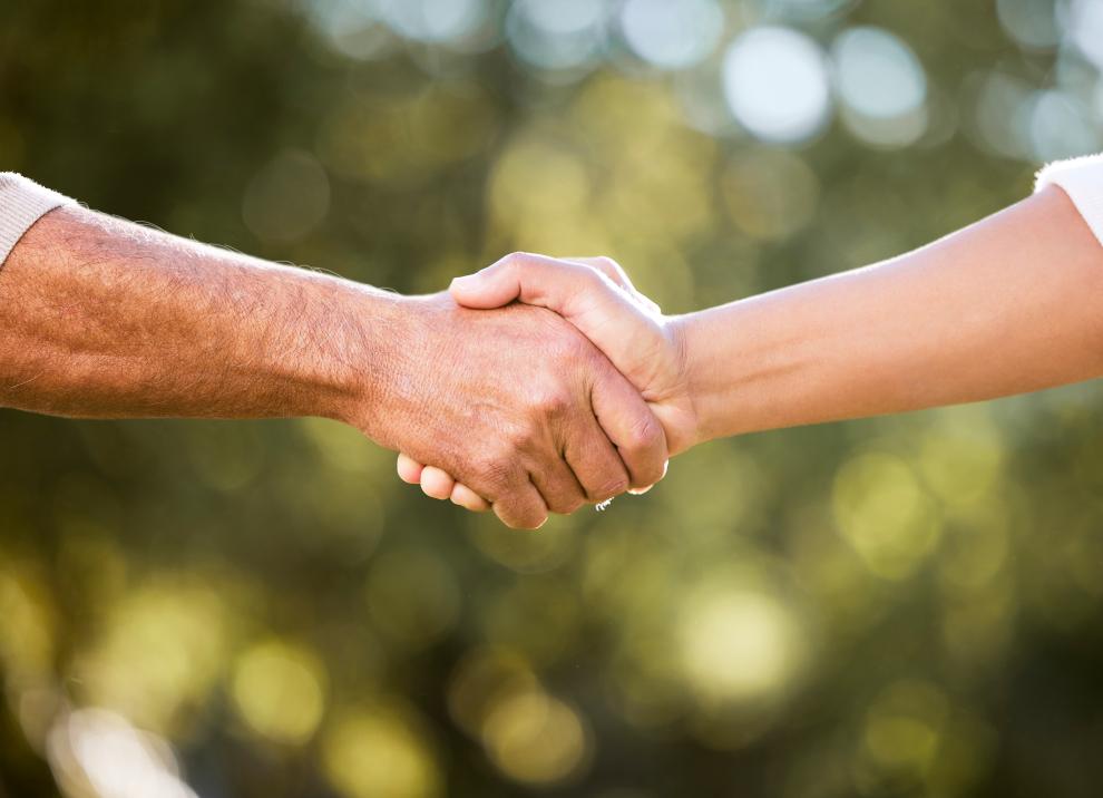 Zwei Menschen reichen sich die Hand